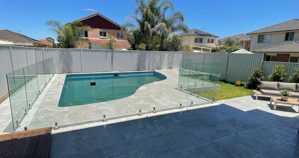 Frameless glass pool fencing surrounding a modern backyard swimming pool